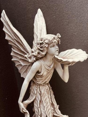 a white statue of a cherub angel with her wings out at Hilltop Vistas Kelowna in Kelowna