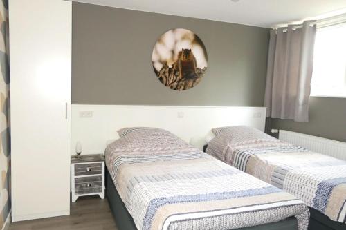 two beds in a bedroom with a mirror on the wall at De Bosuil Drenthe in Spier