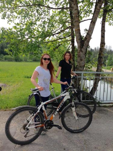 two women are standing next to their bikes at Pension Poschmühle in Traunreut