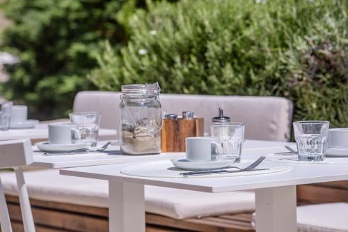 a white table with plates and glasses on it at B&B Vila Sabbia in Lopar