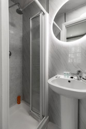 a white bathroom with a sink and a shower at Orlando hotel in London