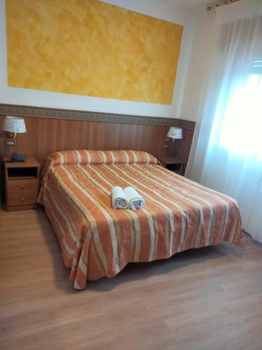 a bedroom with a bed with two shoes on it at Hotel Kristall in San Donà di Piave