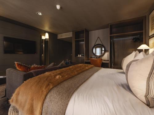 a bedroom with a large bed and a couch at Dakota Glasgow in Glasgow
