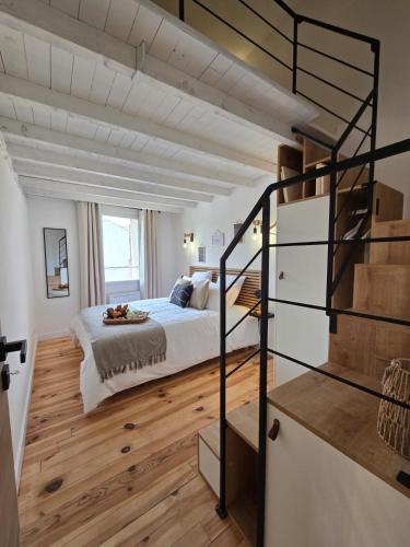 une chambre avec un lit et un escalier en colimaçon dans l'établissement le logis des roues, à LʼIsle-sur-la-Sorgue