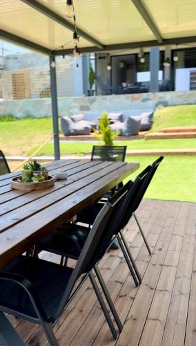 a wooden picnic table with chairs on a deck at Spemaré Residence Halkidiki in Nea Kalikratia