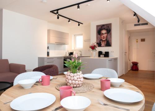 a dining room with a table with white plates on it at Mint@Naschmarkt Premium Apartments in Vienna