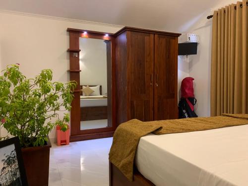 a bedroom with a bed and a mirror and a plant at Serene Deck Kadawatha in Kadawatha