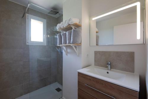 une salle de bain avec un lavabo et une douche avec un miroir dans l'établissement Agréable appartement à 200m de la Plage, à Fréjus