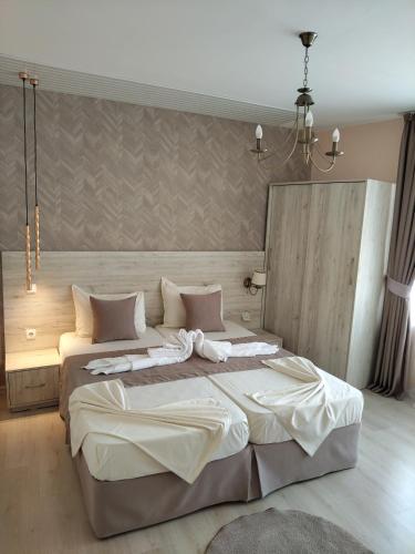 a bedroom with a large bed with white sheets at Guest House Adriya in Primorsko