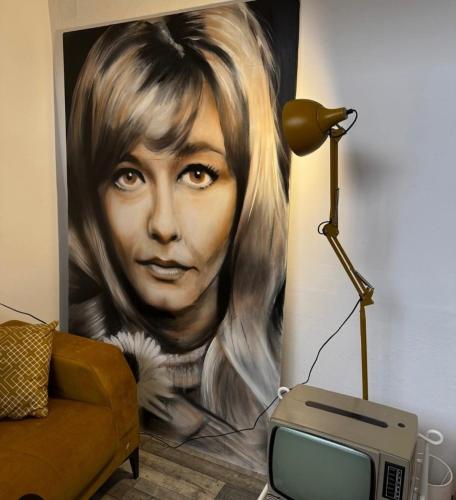 a painting of a woman on a wall with a lamp at Vila Kraljev Breg Fruška Gora Pool and Padel in Čortanovci