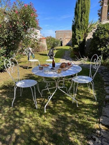 - une table avec deux chaises et une bouteille dans l'établissement Villa familiale proche océan, à Marennes