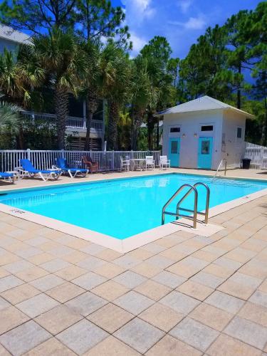 a swimming pool with chairs and palm trees at Heaven's Walk in Indian Pass