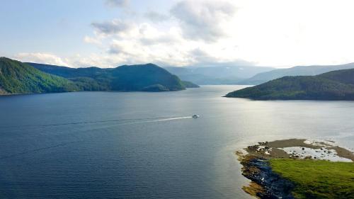 a boat in a large body of water with mountains at Neddies Harbour Inn in Norris Point