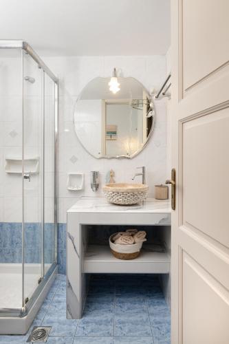 a bathroom with a sink and a mirror at Nafsika Apartments and Studios - Fiskardo in Fiskardho