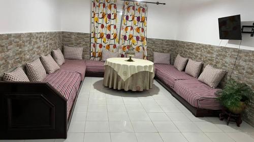 a living room with couches and a table in a room at السعيدية in Saidia 