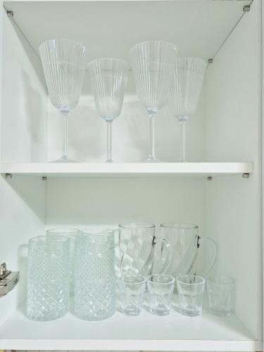 a bunch of glasses sitting on a shelf at Haedeun Stay - Suwon Hwaseong Cozy Family House in Suwon