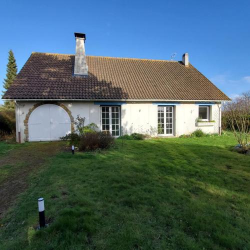 a white house with a garage on a lawn at Maison au calme avec jardin près du Château, forêt et plage in Condette