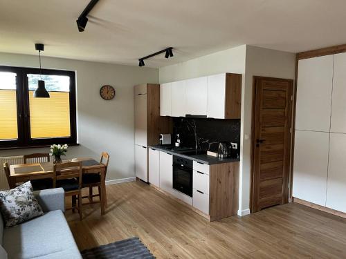 a living room with a kitchen and a table at Apartamenty Rubikon in Kraków