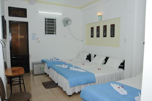 a room with two beds and a table and chairs at Bien Khoi Mini Hotel in Hue