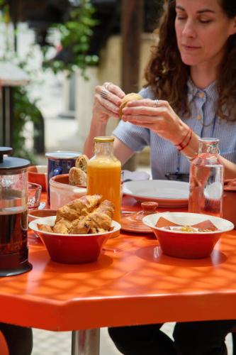 a woman sitting at a table eating food at Moagem Industrial Lodge in Viana do Alentejo