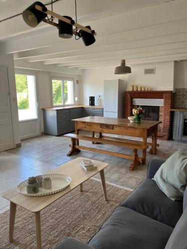 un salon avec une table et une cuisine dans l'établissement La petite Vilaine, maison de campagne, 6 personnes, à La Chapelle-de-Brain