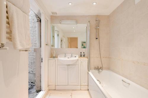 a bathroom with a tub and a sink and a bath tub at Grand Design Deluxe Suite by Buckingham Palace in London