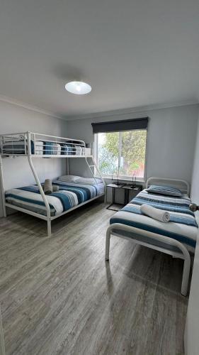 a bedroom with two bunk beds and a window at Waterfront Unit 2 in Kalbarri