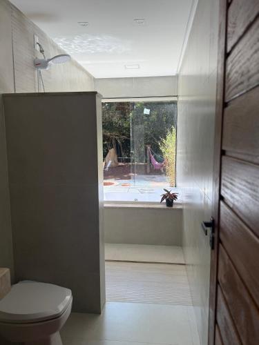 a bathroom with a toilet and a window at Paraíso Capitólio "A Pousada da Dona Perpetua" in Capitólio