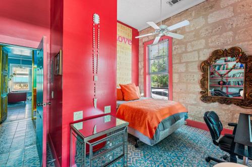 Dormitorio rojo con cama y espejo en Vibrant Location Artistic Home Downtown King Bed, en San Antonio