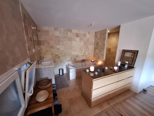 une grande salle de bain avec une baignoire et un lavabo dans l'établissement Maison au bord de l'eau, à Saint-Avit-Saint-Nazaire
