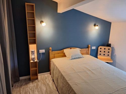 une chambre avec un lit et un mur bleu dans l'établissement Maison au bord de l'eau, à Saint-Avit-Saint-Nazaire