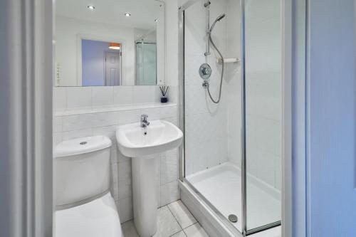 a bathroom with a toilet and a sink and a shower at Modern Comfort 2BR Flat with Free Parking in Oadby in Oadby