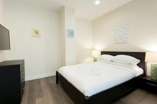 a bedroom with a bed with white sheets and pillows at Simple Studio Walk to MGH Beacon Hill and North End in Boston