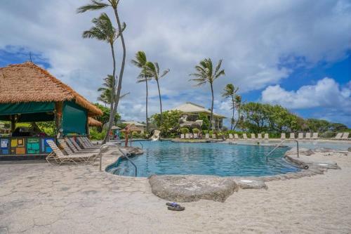 a swimming pool at a resort with palm trees at Simple but Idyllic Oceanfront Resort w King Bed in Lihue