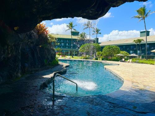 a swimming pool in the middle of a resort at Simple but Idyllic Oceanfront Resort w King Bed in Lihue