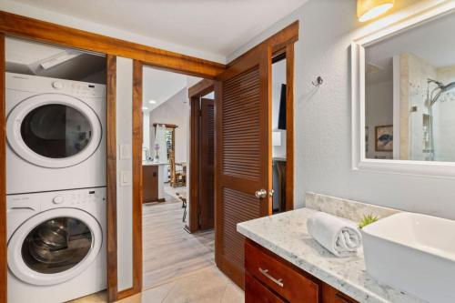 a bathroom with a washing machine and a sink at Tropical Treehouse Near the Beach in Koloa