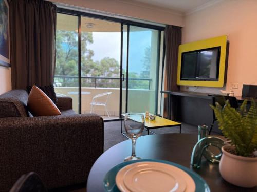 a living room with a couch and a table with a wine glass at Stylish City Stay in Parramatta Pool , Parking in Sydney