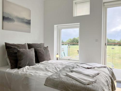a white bedroom with a bed with towels on it at Convenient Apartment for 2 in Aarhus