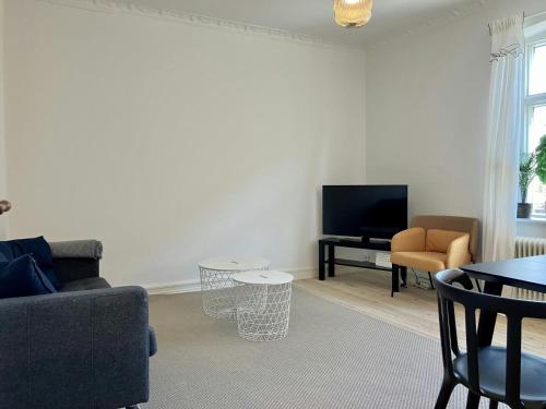 a living room with a couch and a tv at Convenient Apartment for 2 in Randers