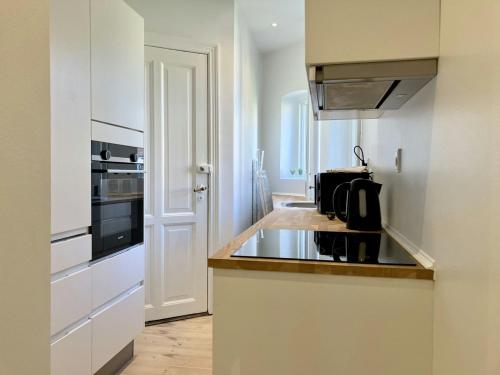 a white kitchen with a sink and a stove at Convenient Apartment for 2 in Randers