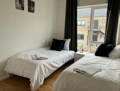two beds in a room with a window at Spacious Apartment for 7 in Sabro