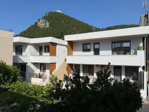 ein Wohnhaus mit einem Hügel im Hintergrund in der Unterkunft Heleon Luxury Apartments in Parga