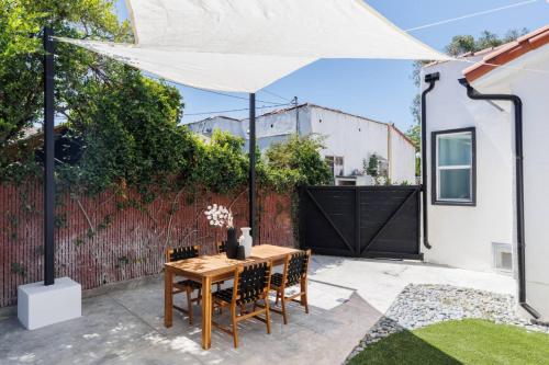 a patio with a table and chairs under a white umbrella at Iconic LACasita -FoodieBobaliciousCity- Mins2DTLA in Alhambra