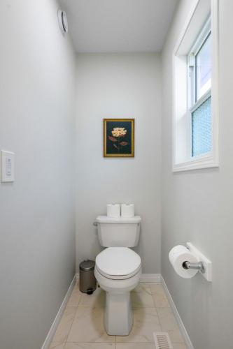 a white bathroom with a toilet and a window at The Ultimate Getaway with Central AC, 3 King Beds, Hot Tub, Pool Table and More in Balzac