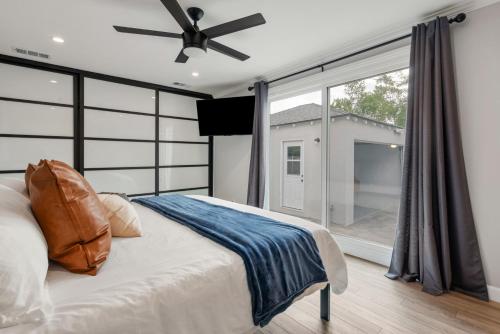 Un dormitorio con una cama y una ventana grande. en Luxury Hangout - Private Spa - Game Room - Arcade, en Long Beach