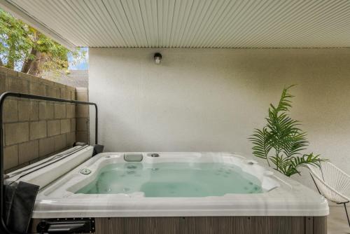 bañera en una habitación con planta en Luxury Hangout - Private Spa - Game Room - Arcade, en Long Beach