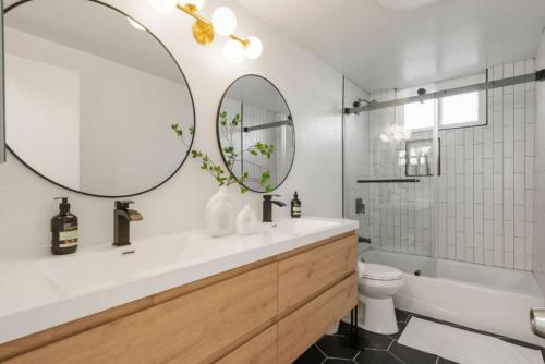 a bathroom with a sink and a tub and a mirror at Designer Dream- Pool and spa- Game Room- Sleeps 10 in Los Angeles