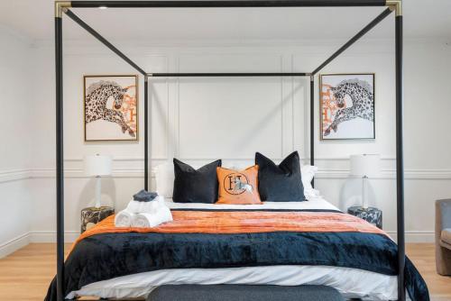 a bedroom with a canopy bed with orange and blue pillows at Designer Dream- Pool and spa- Game Room- Sleeps 10 in Los Angeles