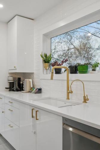 a white kitchen with a sink and a window at The Tranquil lake-house at Fletchers Lake in Fall River