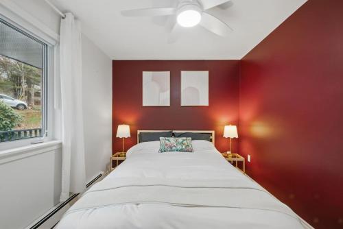 a bedroom with a large bed with a red wall at The Tranquil lake-house at Fletchers Lake in Fall River